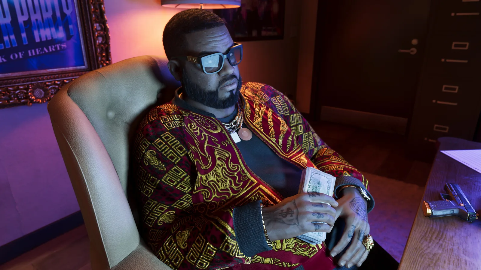 Boobie holding a stack of cash, sitting back in a chair at a desk with a handgun on top of it.