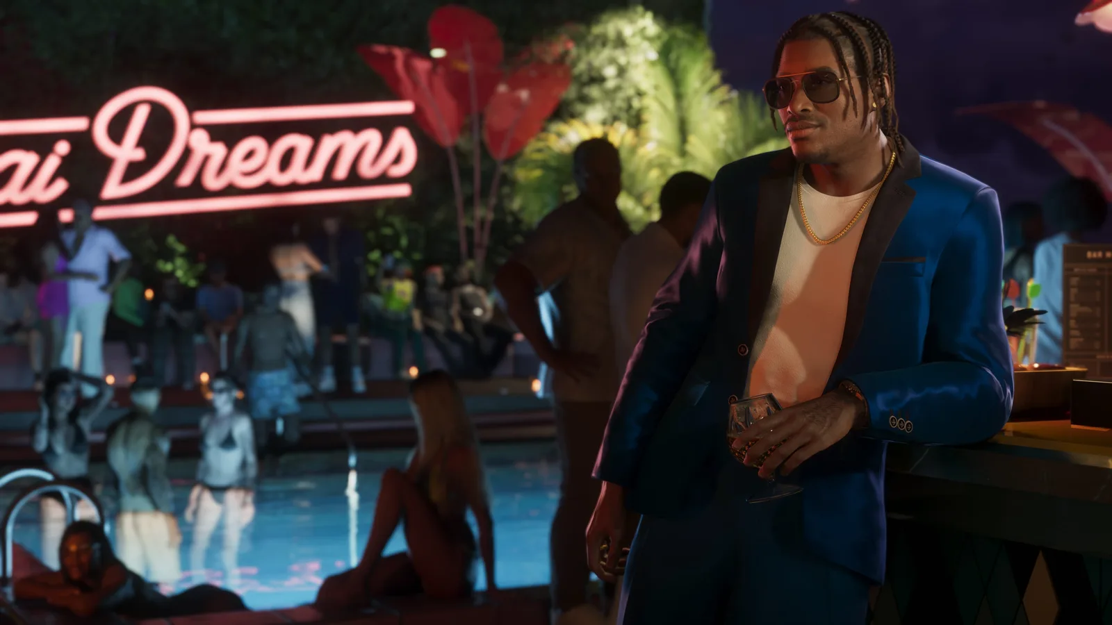 Dre'Quan in a suit leaning against a bar at a nighttime pool party.