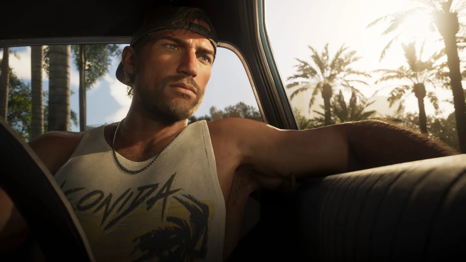 Jason inside a car sitting behind the wheel looking into the distance.